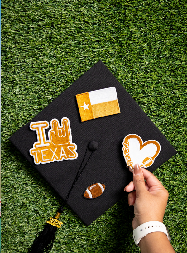 Graduation cap with decorative stickers on a grass background