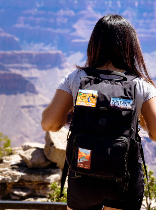 Girl over looking the canyon with National Park Patches Attached to Backpack