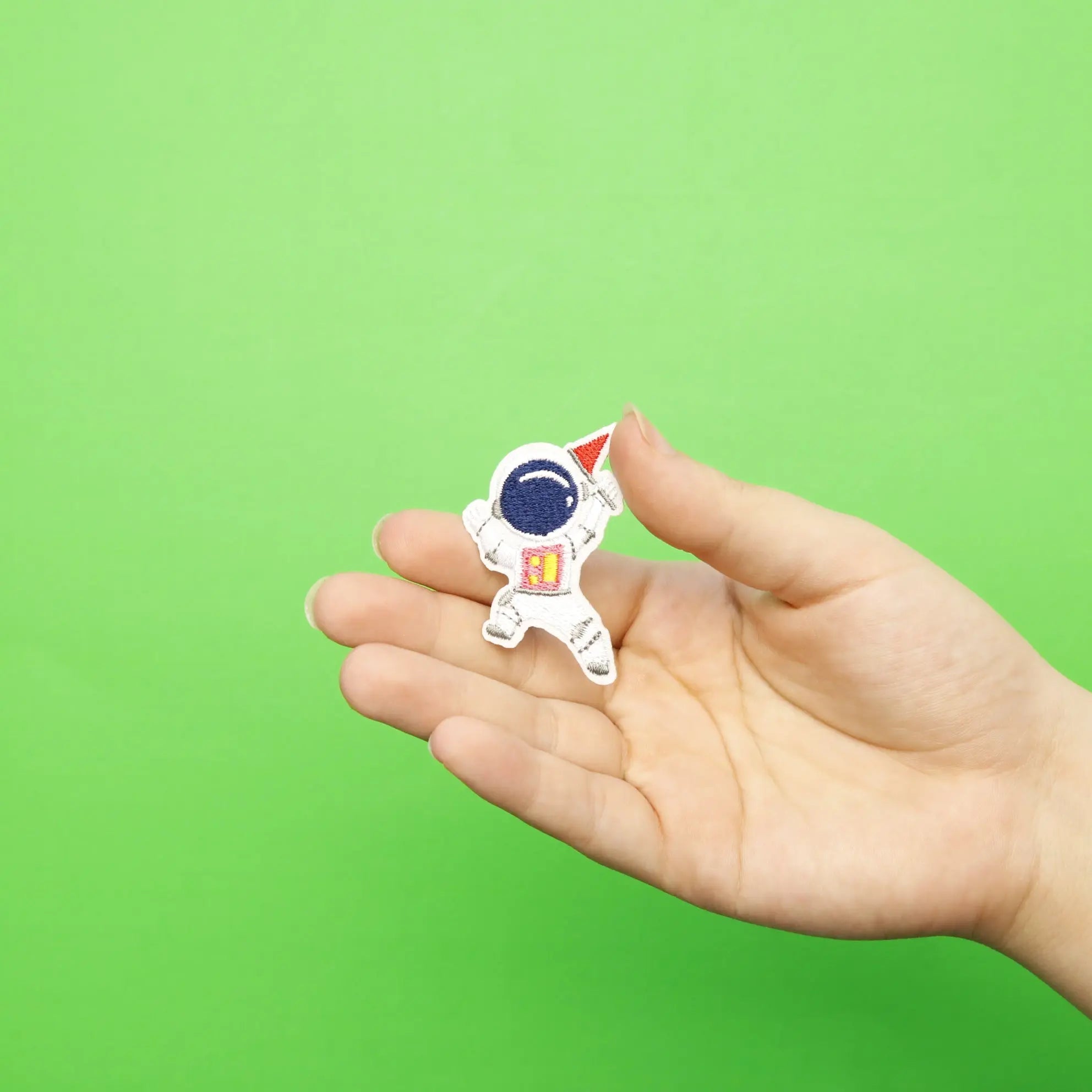 Small Pink Astronaut Holding A Small Red Flag Embroidered Iron On Patch